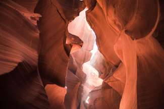 De upper Antelope Canyon bestaat uit tientallen meters hoge glooiende zandwanden die door de zon een waar lichtspektakel geven.