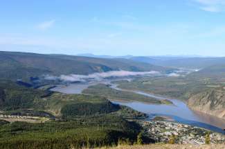Een weids uitzicht over Dawson City en de Yukon-rivier.
